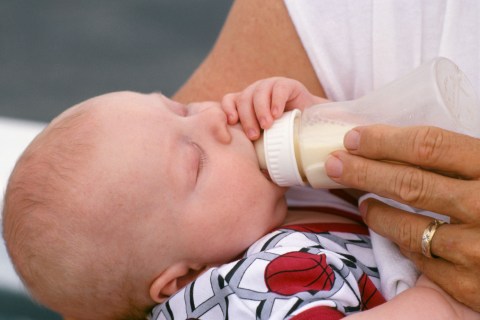 Newborn baby boy being bottle fed