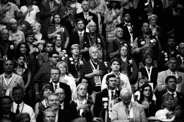 image: Delegates listen to the National Anthem on the final day of the Republican National Convention at the Tampa Bay Times Forum in Tampa, Florida, Aug. 30, 2012.