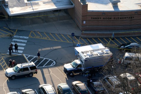 image: Officials on the scene outside of Sandy Hook Elementary School in Newtown, Conn., where Adam Lanza opened fire in a shooting that left 27 people dead, including 20 children, Friday, Dec. 14, 2012. 