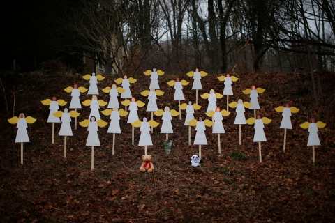 image: Twenty-seven wooden angel figures are seen placed in a wooded area beside a road near the Sandy Hook Elementary School for the victims of a school shooting in Newtown, Conn., Dec. 16, 2012.