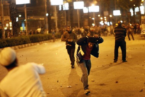 image: Members of the Muslim Brotherhood and supporters of Egyptian President Mohammed Morsi run for cover as they clash with anti-Morsi demonstrators on the road leading to the Egyptian presidential palace in Cairo, Dec. 5, 2012.