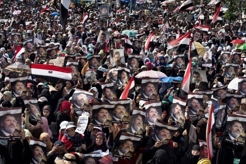 Egyptian supporters of deposed president Mohamed Morsi wave their national flag as they attend a rally in support of the former Islamist leader outside Rabaa al-Adawiya mosque in Cairo, on July 8, 2013.