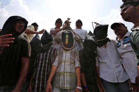 Indian protesters stage a mock hanging scene demanding death sentences for four men after a judge convicted them in the fatal gang rape of a young woman on a moving New Delhi bus last year, in New Delhi, Sept. 10, 2013.