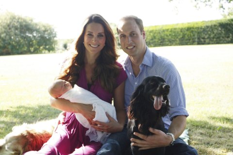 The Duke and Duchess of Cambridge with their son Prince George in the garden of the Middleton family home in Bucklebury, Berkshire surrounded by Tilly the retriever (a Middleton family pet), and Lupo, the couple's cocker spaniel, Aug. 20, 2013. 