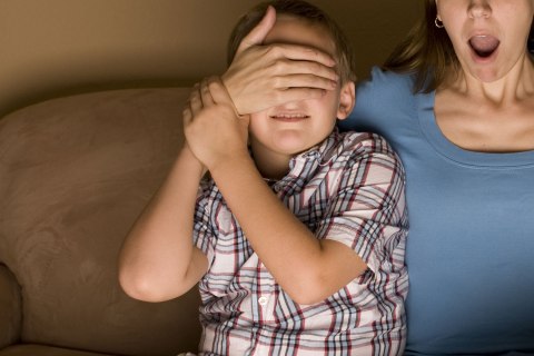 Parent shields child's eyes during movie