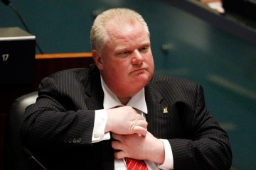 Toronto Mayor Rob Ford adjusts his tie during a special council meeting at City Hall in Toronto