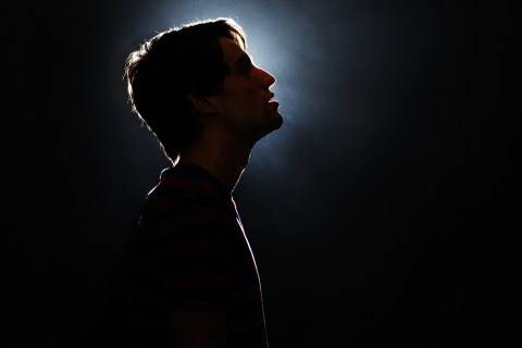 Silhouette of young man looking up.