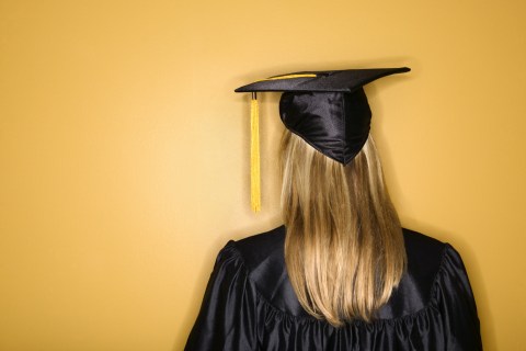 Young woman wearing graduation gown