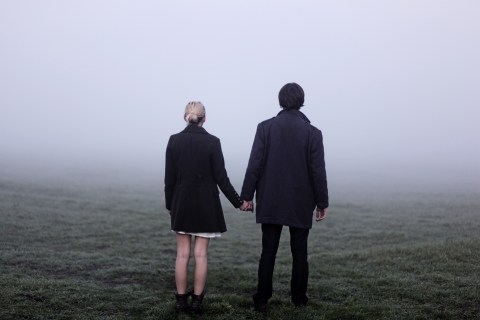 Couple holding hands outside in thick fog
